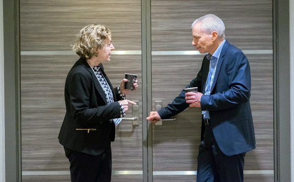 a woman left and man right having a lean communities discussion before opening a closed door