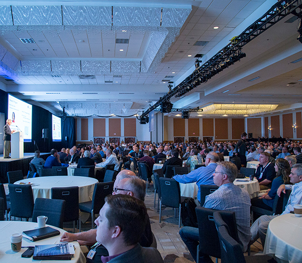 A wide view of LCI Congress with people sitting at round tables in a presentation room